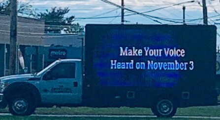 A mobile LED billboard on a truck reads Make Your Voice Heard on November 3